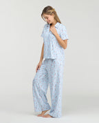 Pijama azul claro para mujer con estampado de perros, camisa de botones y pantalón largo en tela piel de durazno.