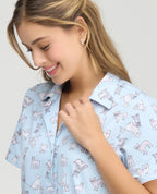 Primer plano de pijama azul claro para mujer con estampado de perros, cuello clásico y botones en tela piel de durazno.
