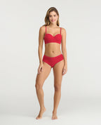 Modelo usando brasier strapless rojo de realce medio con cargaderas removibles y varillas laterales para soporte.