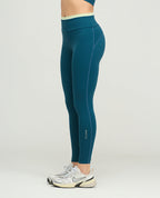 Leggins deportivos para mujer en color azul petróleo, silueta ajustada, talle alto con vivo claro y bota tubo.