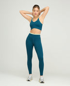 Leggins deportivos talle alto para mujer en color azul petróleo con silueta ajustada y bota tubo para gimnasio.
