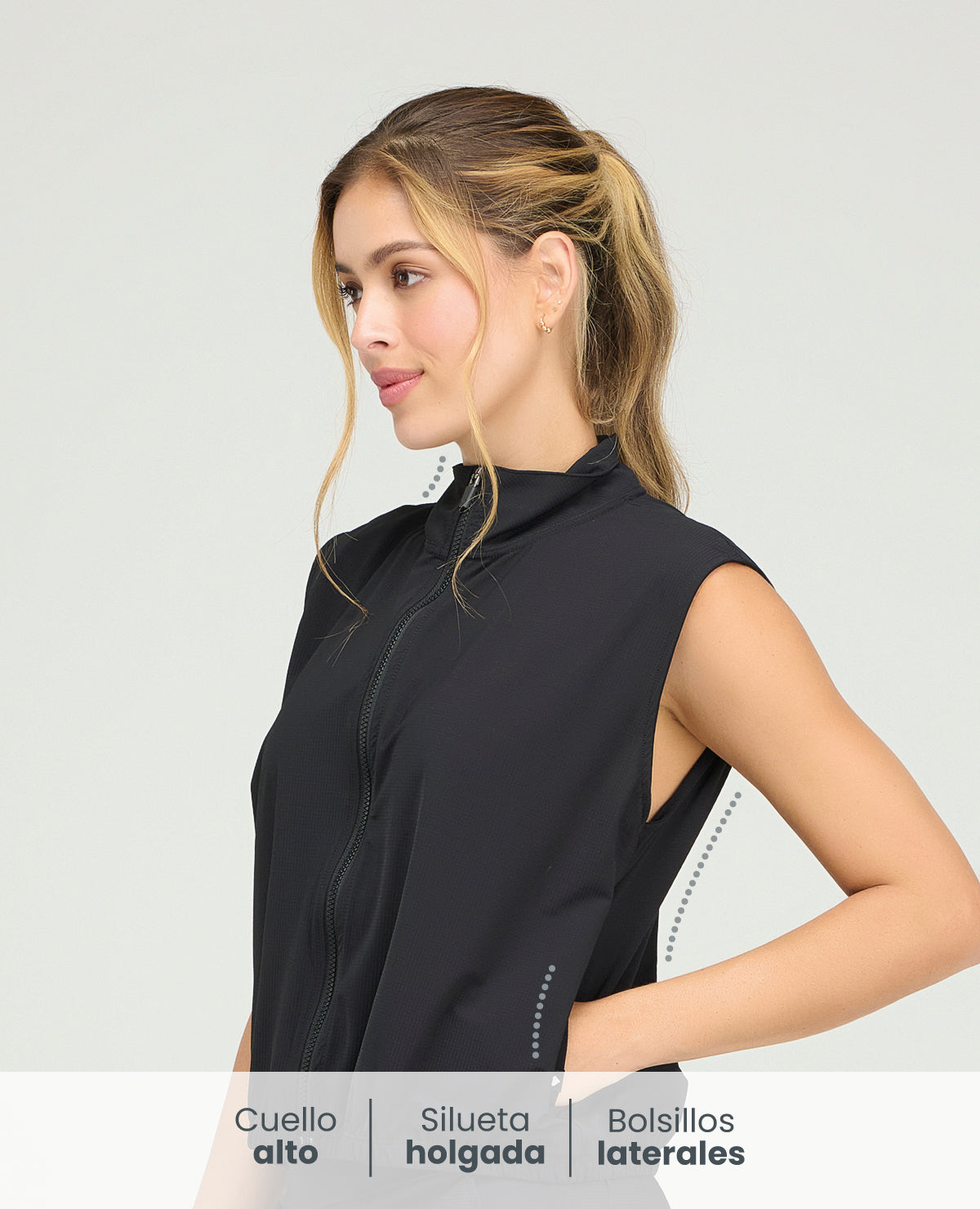 Chaleco deportivo negro de cuello alto para mujer con cremallera frontal, silueta holgada y bolsillos laterales.