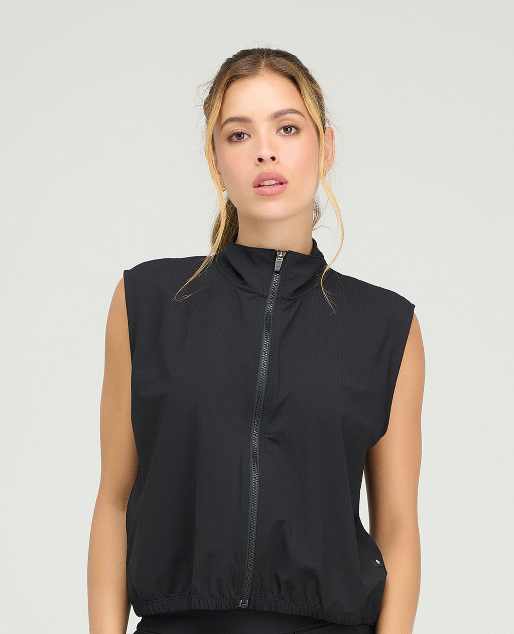 Chaleco deportivo negro de cuello alto con cremallera frontal y hombros amplios para mujer en Shopify Colombia.