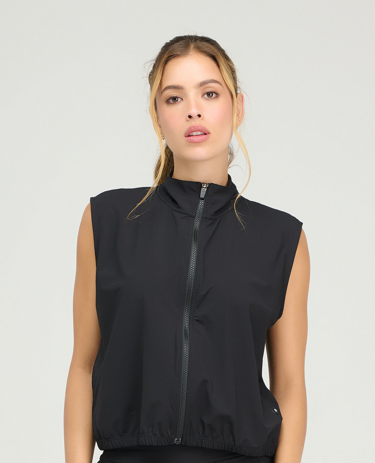 Chaleco deportivo negro de cuello alto con cremallera frontal y hombros amplios para mujer en Shopify Colombia.