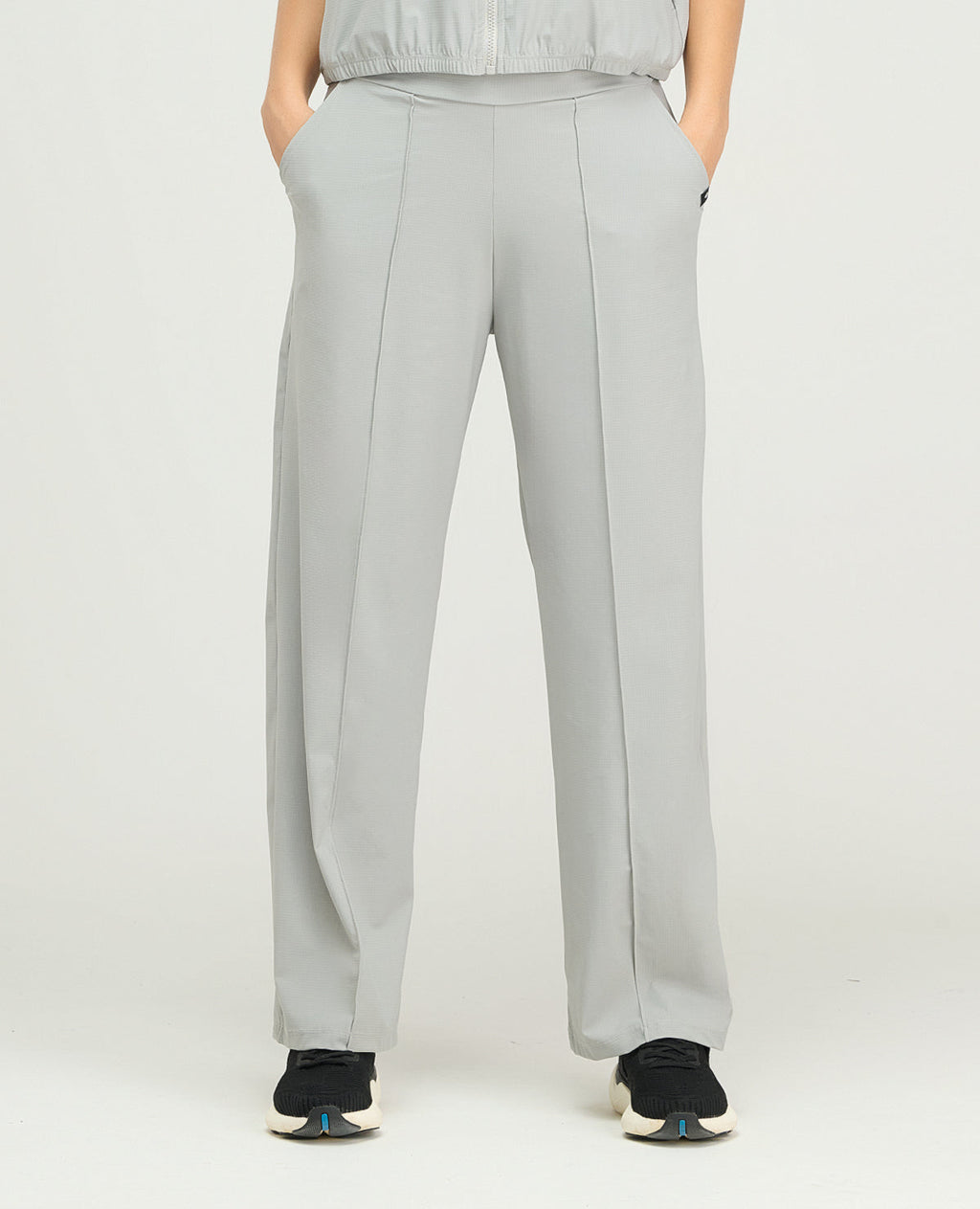 Pantalón sudadera deportiva para mujer gris claro de bota recta, silueta amplia y bolsillos laterales.