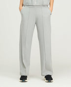 Pantalón sudadera deportiva para mujer gris claro de bota recta, silueta amplia y bolsillos laterales.