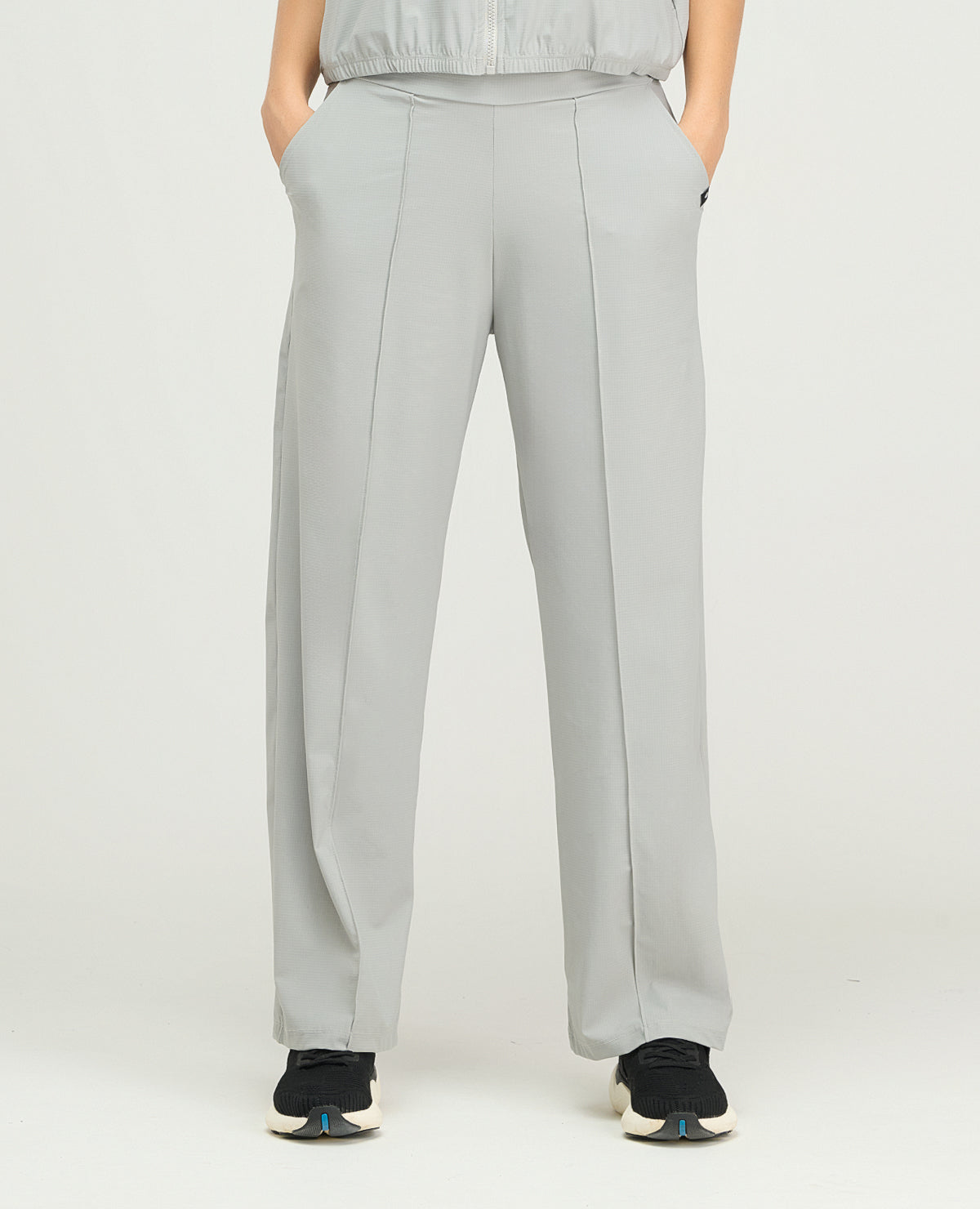 Pantalón sudadera deportiva para mujer gris claro de bota recta, silueta amplia y bolsillos laterales.