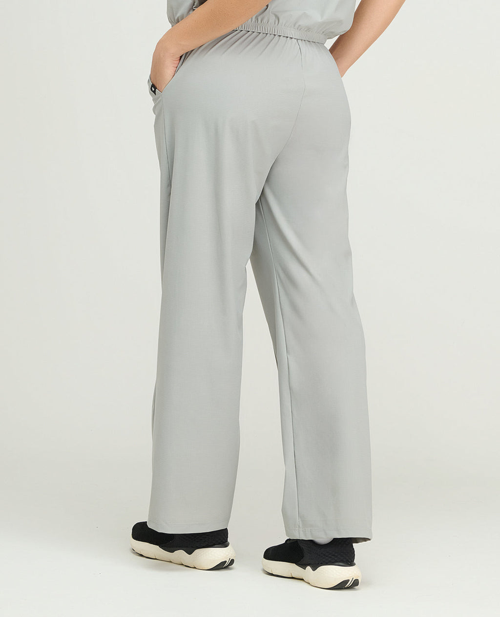 Pantalón de sudadera deportiva gris para mujer, silueta de bota recta, bolsillos laterales y ajuste elástico posterior.