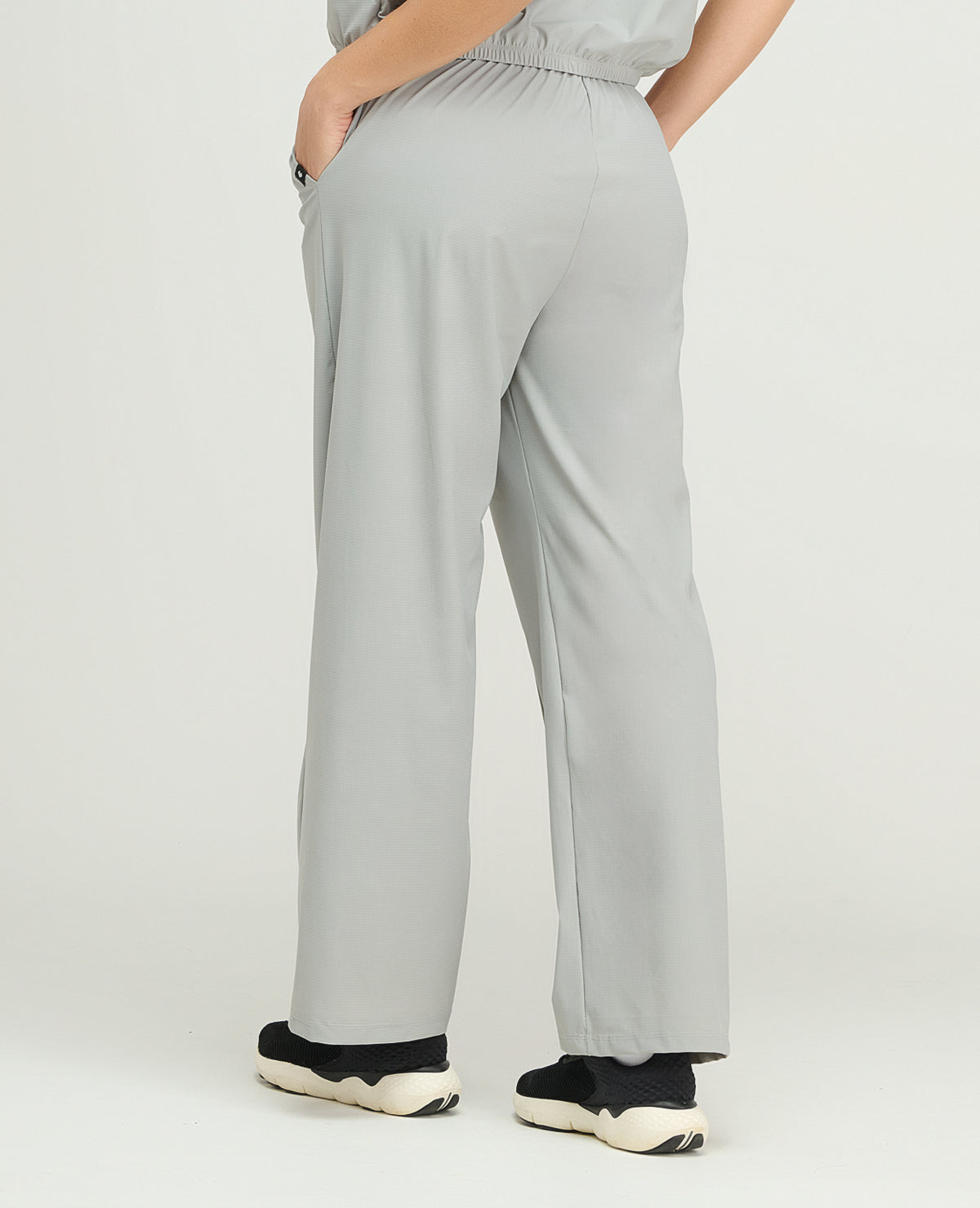 Pantalón de sudadera deportiva gris para mujer, silueta de bota recta, bolsillos laterales y ajuste elástico posterior.