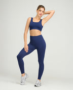 Modelo usando top deportivo azul sin costuras con escote cuadrado y leggings a juego para entrenamiento fitness.