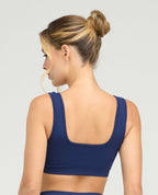 Espalda de top deportivo azul marino sin costuras con cargaderas anchas y escote cuadrado en tecnología seamless.