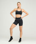 Modelo en short deportivo tipo ciclista negro de silueta ajustada, con tiro alto y corte limpio sin elásticos.