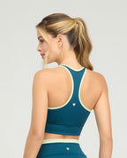 Espalda de top deportivo verde azulado con cargaderas anchas, silueta ajustada y detalles en color lima.
