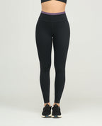 Leggins deportivos negros para mujer, silueta ajustada, talle alto con vivo morado y bota tubo para gimnasio.