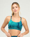 Top deportivo para mujer en color azul turquesa con estampado marmoleado, cargaderas dobles y copas fijas suaves.