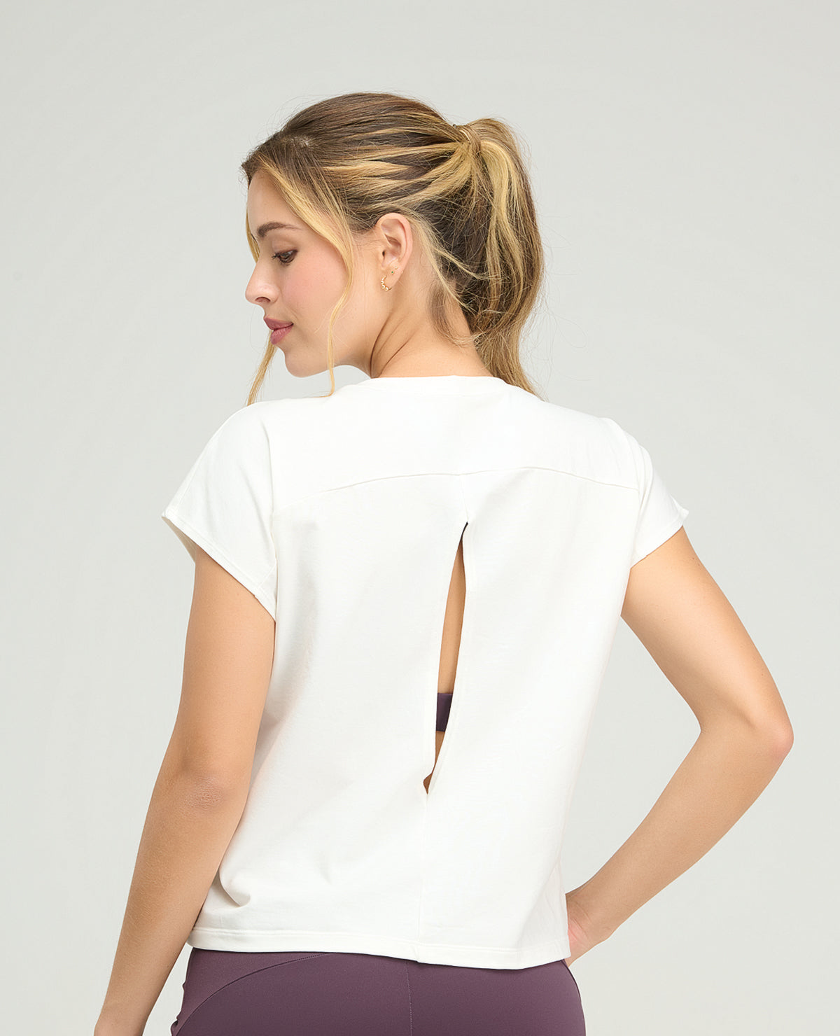 Camiseta deportiva blanca holgada para mujer con abertura en la espalda y manga rodada de St. Even.