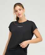 Mujer usando camiseta deportiva negra holgada con cuello redondo y manga rodada St. Even para entrenamiento.