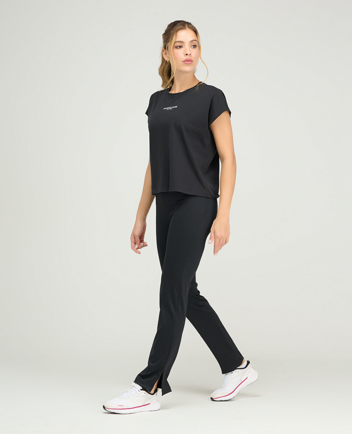 Camiseta deportiva negra de silueta holgada y cuello redondo para mujer con manga rodada y tejido ligero.