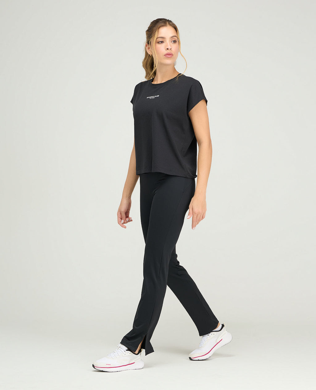 Camiseta deportiva negra de silueta holgada y cuello redondo para mujer con manga rodada y tejido ligero.