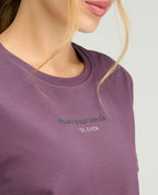 Primer plano de camiseta deportiva morada con cuello redondo y estampado reflectivo de la marca St. Even.