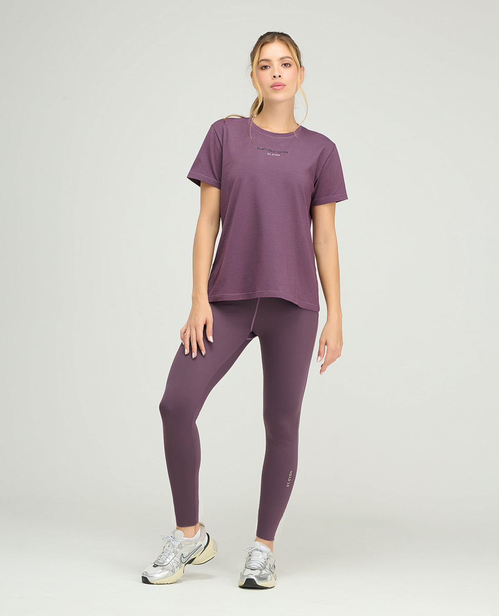 Camiseta deportiva mujer color uva, cuello redondo y silueta holgada con estampado reflectivo para gym.