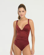 Vestido de baño entero color vino con escote cruzado, realce medio y drapeado lateral para control de abdomen.