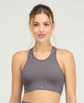 Modelo usando top deportivo gris seamless sin costuras para mujer, con cuello redondo y ajuste ergonómico.
