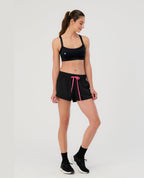 Mujer usando top deportivo negro St Even de tela inteligente y shorts para gimnasio. Ropa deportiva colombiana.