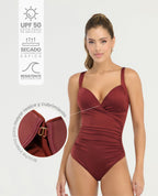 Vestido de baño entero color vino con escote cruzado, drapeado lateral y detalle de broche interno de realce.