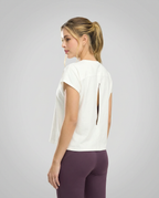 Mujer en ropa deportiva St.Even con camiseta holgada color ivory, manga rodada y detalle de abertura en la espalda.