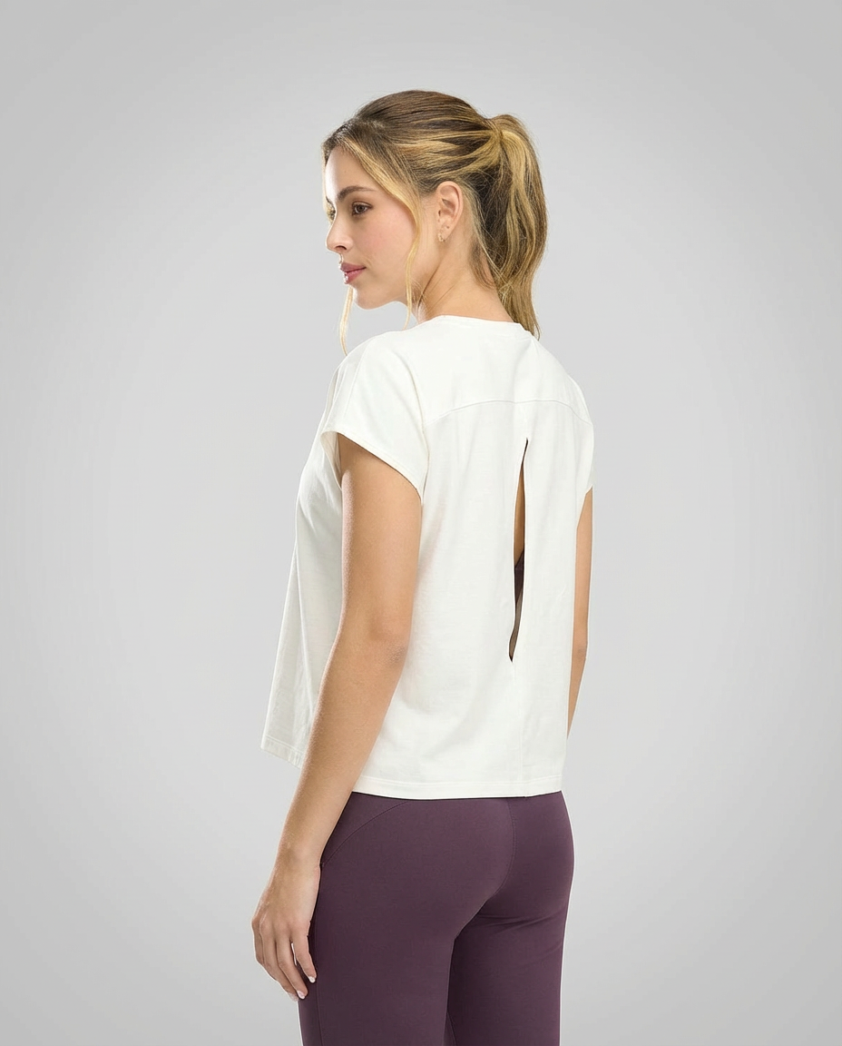 Mujer en ropa deportiva St.Even con camiseta holgada color ivory, manga rodada y detalle de abertura en la espalda.