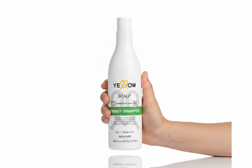 Yellow Scalp Energy Shampoo sostenido por una mano